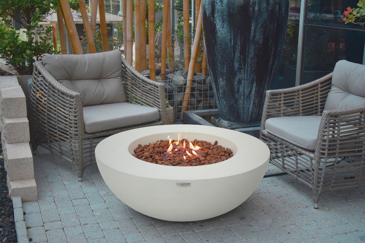 Ohnisko LUNAR BOWL Cream White v záhrade s prúteným sedením